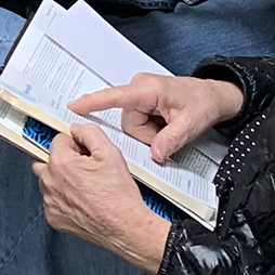 index finger pointing to scripture in open bible