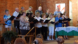 alpine community church choir standing and singing the anthem