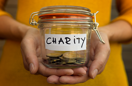 hands holding glass jar filled with coins