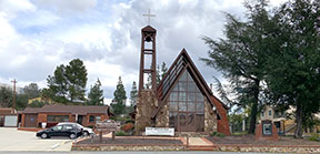 street view of church sanctuary showing steeple and glass front wall and office and parking lot