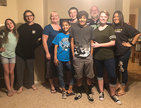 seven youths posing with pastor ken and parent robin at ken's home