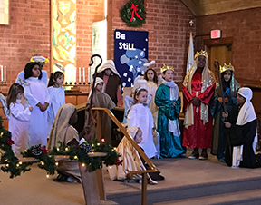 thirteen children performing the christmas pageant at the alter